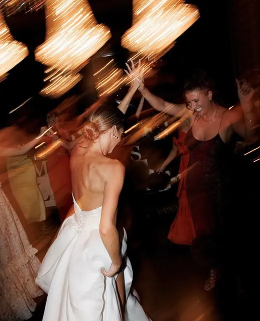 A bride dancing in motion blur under warm chandelier light